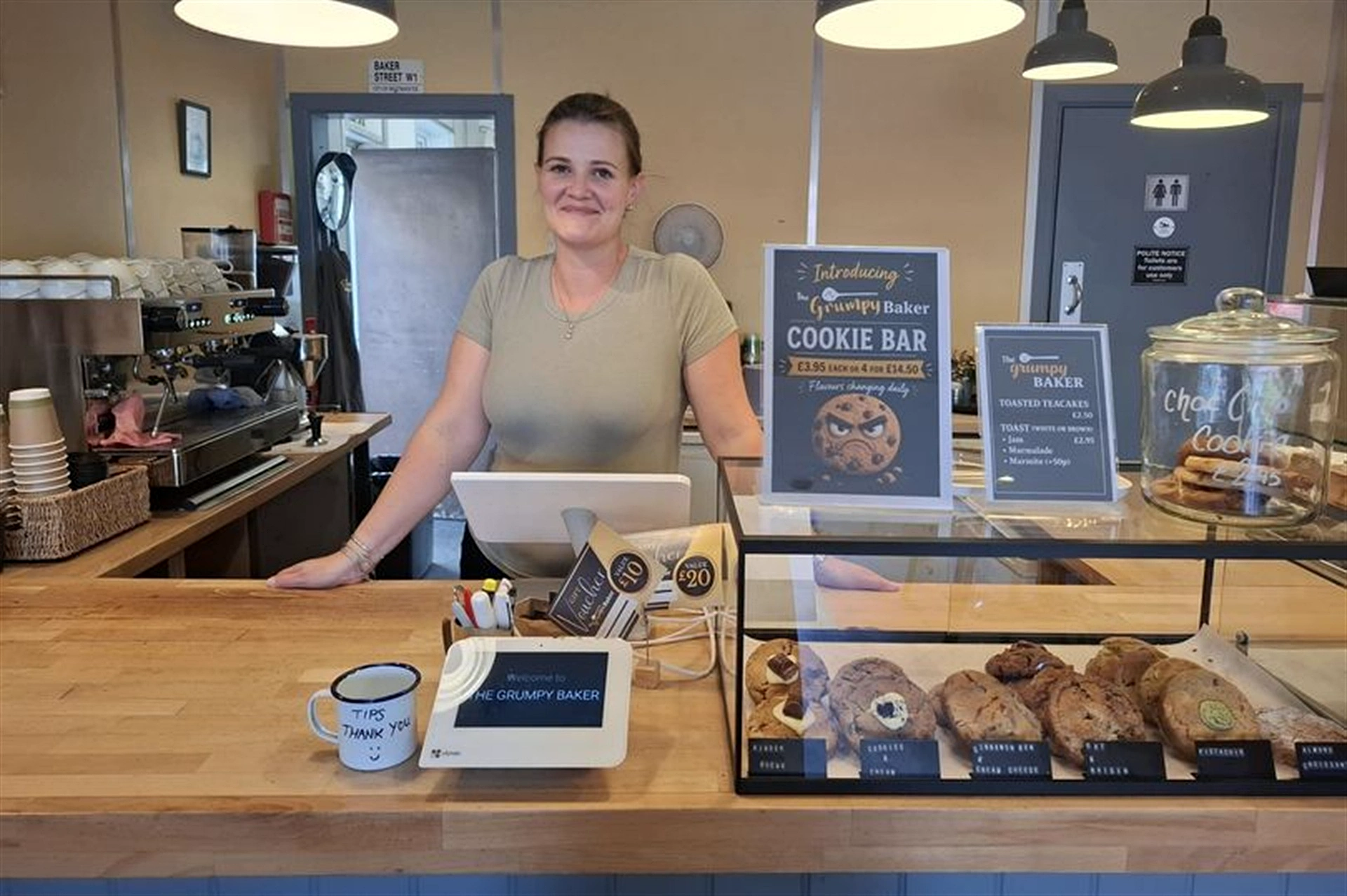 The counter at The Grumpy Baker with a member of the team and fresh cookies